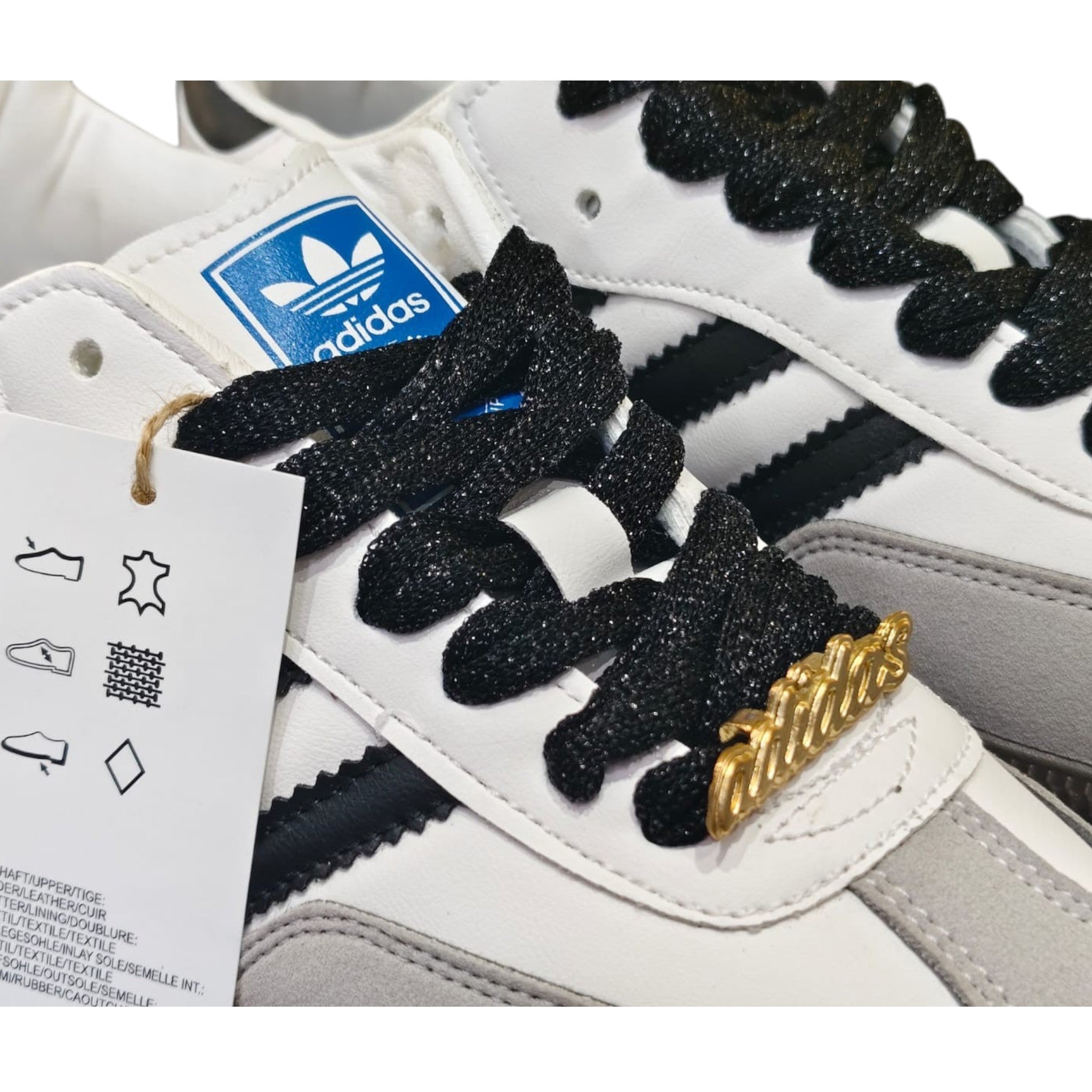 Zapatillas Adidas Samba OG de cuero blanco y ante gris con cordones negros y detalles dorados. Planet Shoes Sneakers.