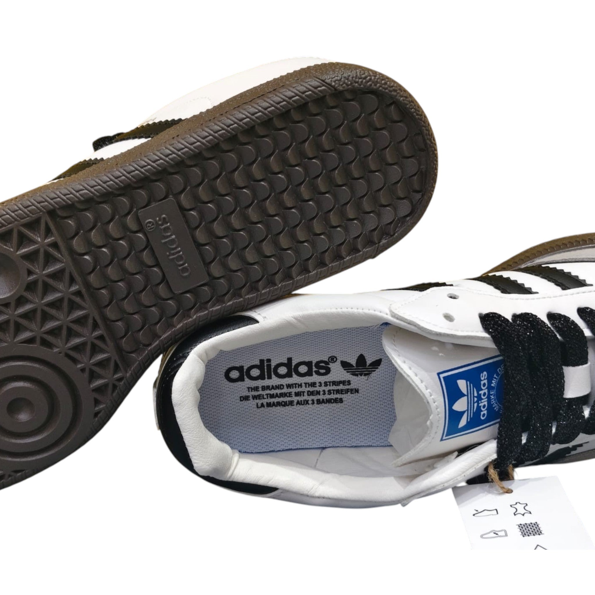 Zapatillas Adidas Samba OG de cuero blanco y ante gris con tres rayas negras y suela de goma marrón.