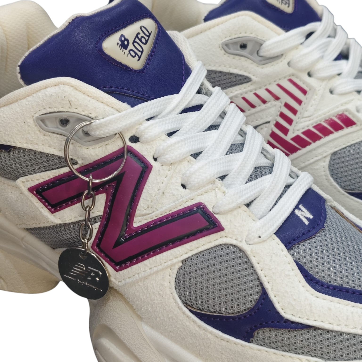 Zapatillas New Balance 9060 de Planet Shoes Sneakers en ante blanco roto con detalles morados y fucsia. Malla transpirable y suela gruesa.