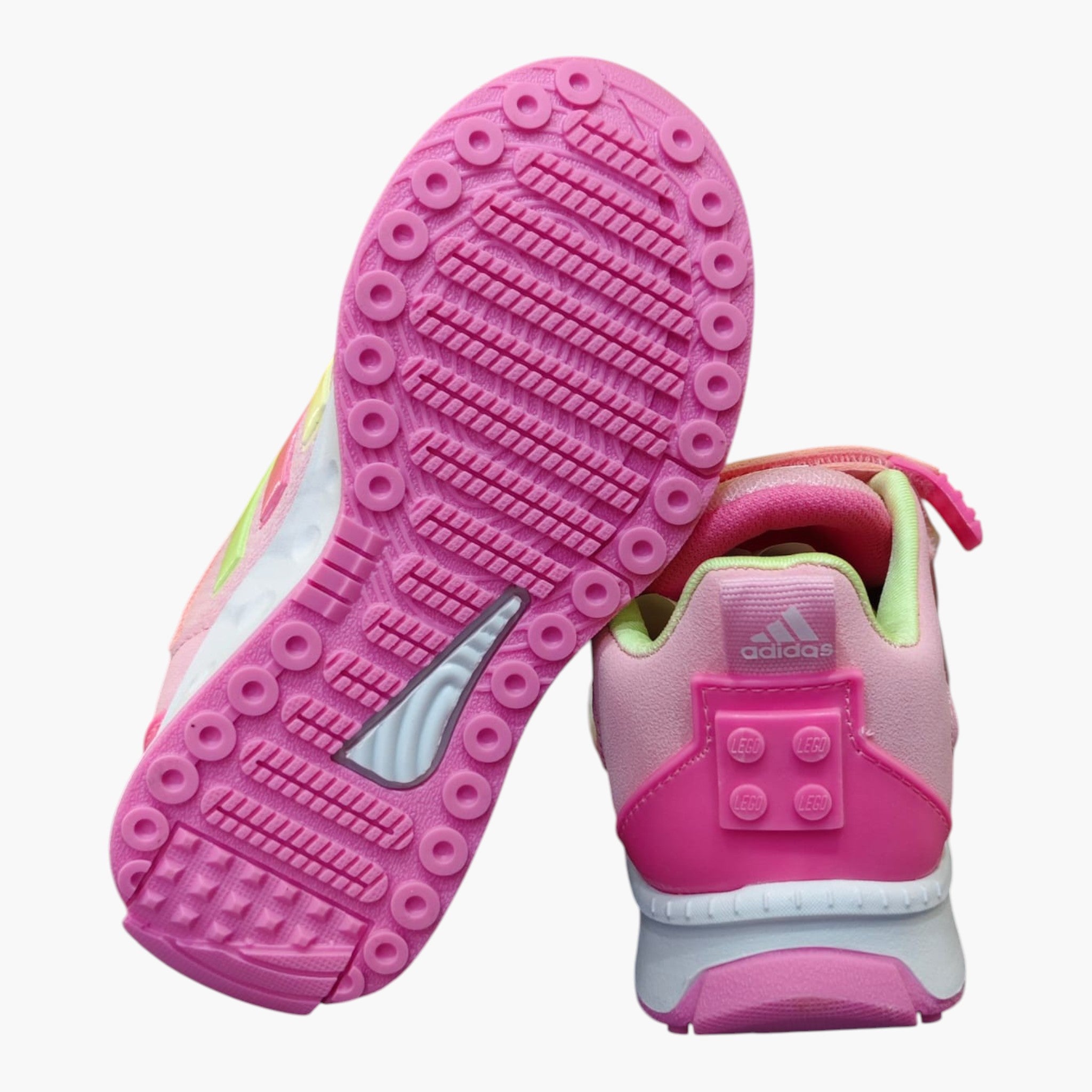 Tenis Adidas para niña en colaboración con Lego, color rosa con detalles en amarillo y verde. Suela de goma rosa con patrón de tracción.