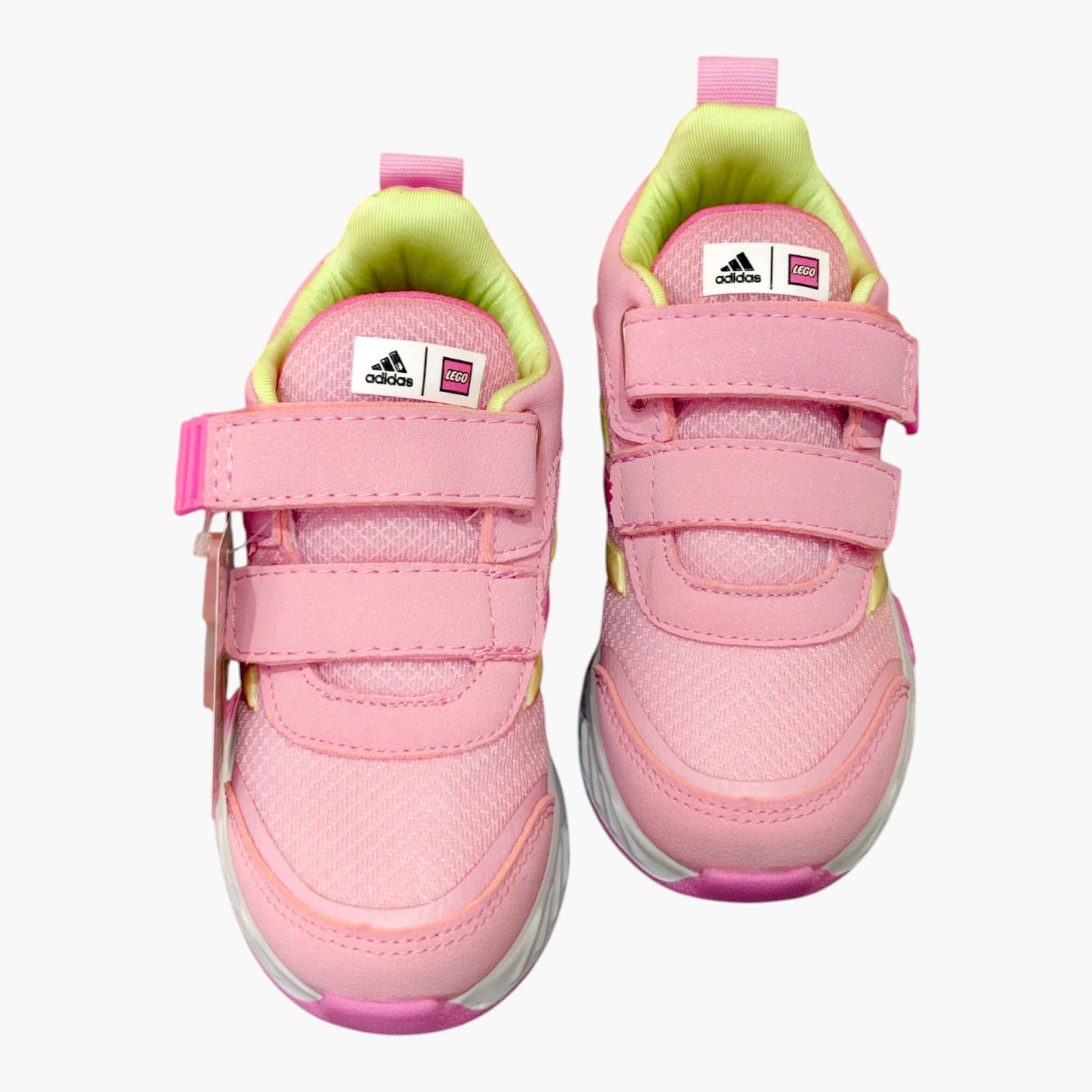 Tenis rosas de velcro para niña Adidas x Lego, con detalles amarillos y suela blanca.