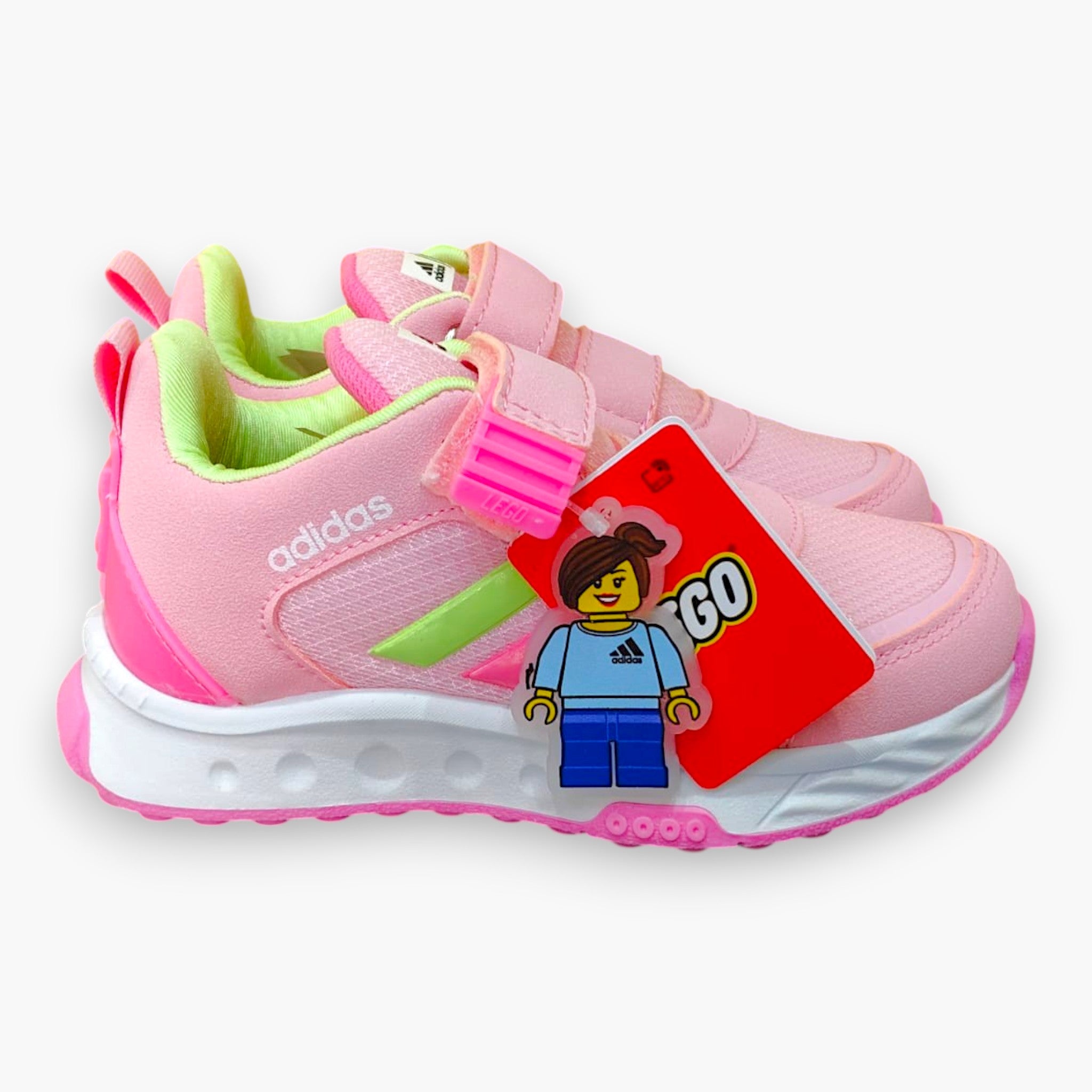Tenis rosas de velcro para niña de Adidas x Lego con detalles verdes y suela blanca. Incluye charm de Lego.