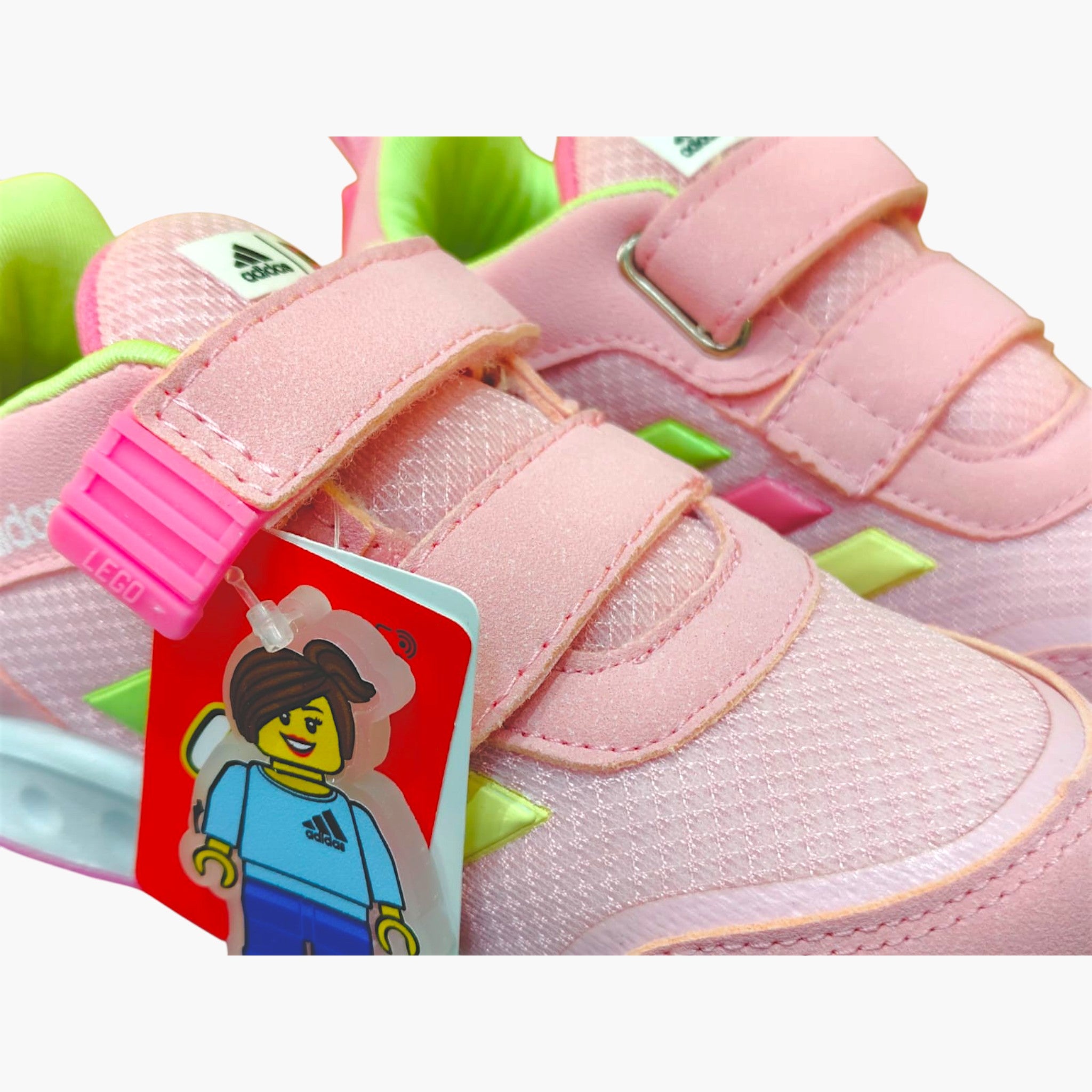 Tenis rosas de contacto para niña de Planet Shoes Sneakers, con detalles de Lego y tres velcros. Suela blanca y detalles verdes y rosas.