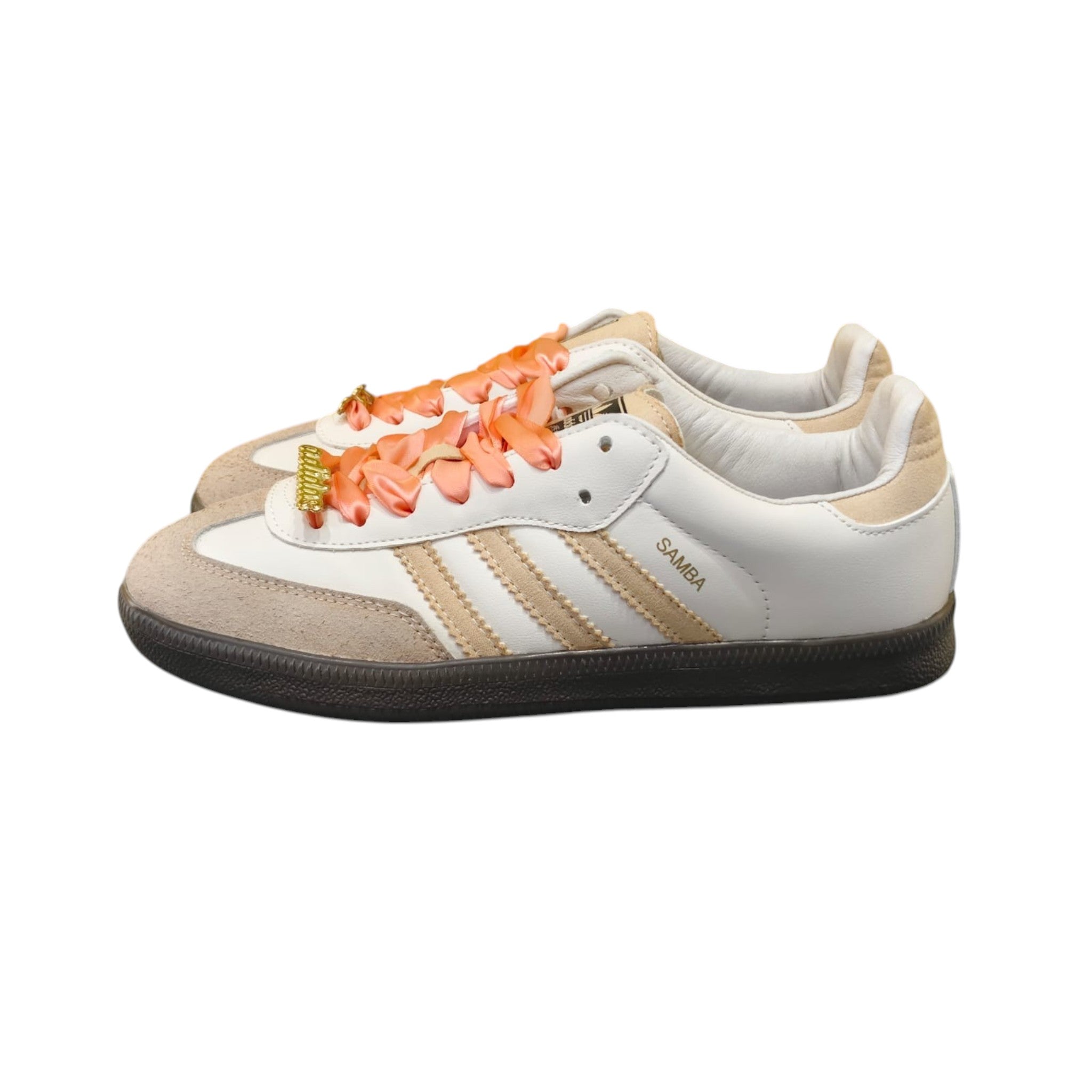 Zapatillas Adidas Samba Classic de mujer en cuero blanco y ante beige con cordones de satén coral y detalles dorados.