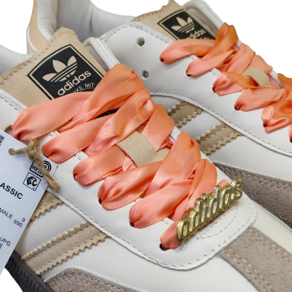 Zapatillas Adidas Samba Classic de mujer en cuero blanco y ante beige con cordones de satén coral y detalles dorados.